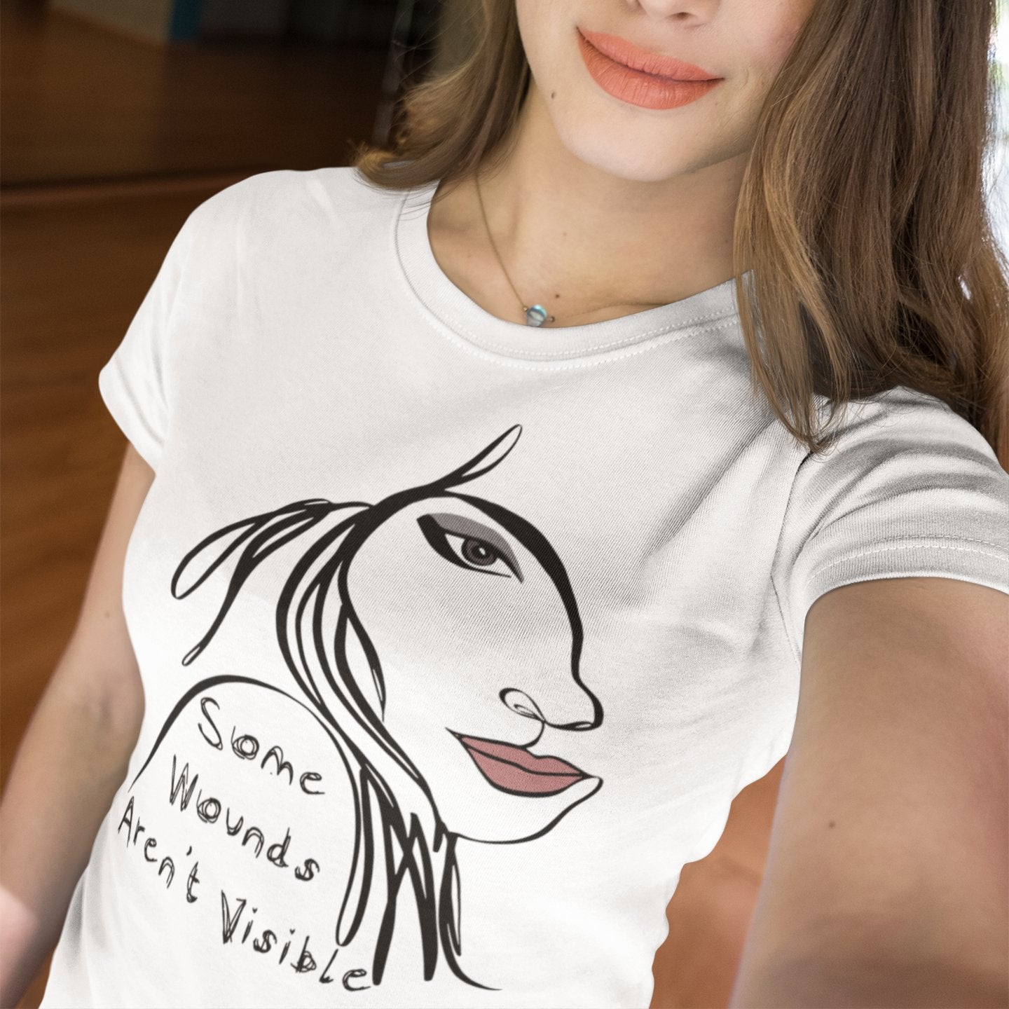 Woman wearing a some wounds aren't visible t-shirt with a profile picture of a woman